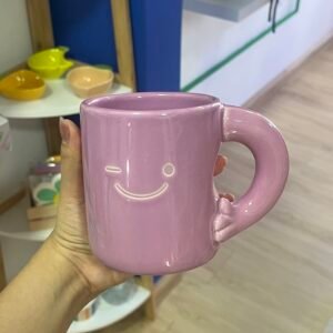 Taza morada con cara feliz y asa