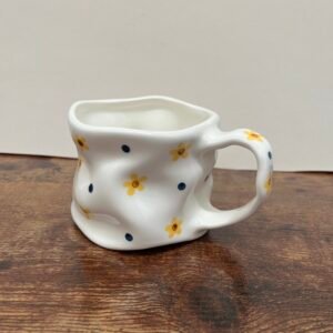 Taza con flores amarillas y puntos